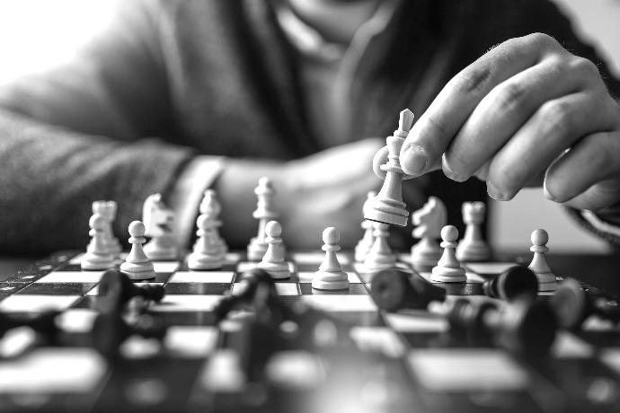 depth of field photography of man playing chess